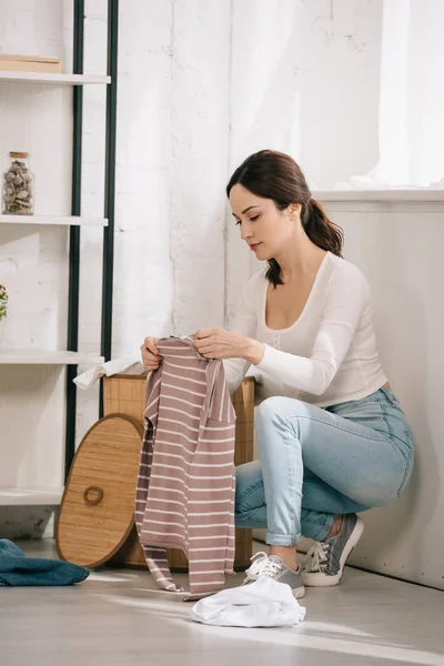 Jong Huisvrouw Holding Stripped Pullover Buurt Wasmand — Stockfoto