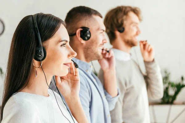 Vista Lateral Feliz Corredor Tocando Auriculares Cerca Compañeros Trabajo Oficina — Foto de Stock