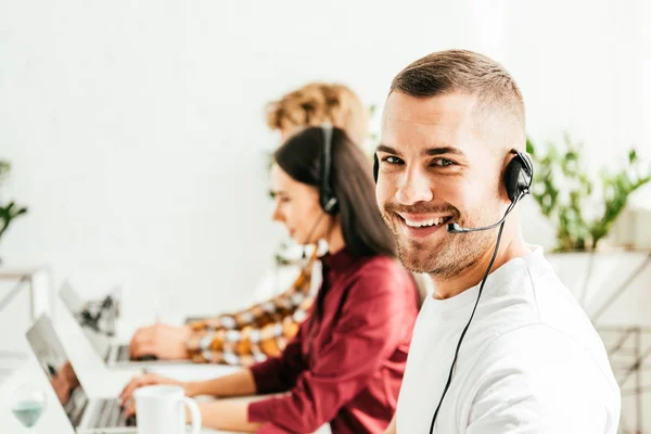 Enfoque Selectivo Corredor Alegre Auriculares Que Trabajan Oficina Con Compañeros — Foto de Stock