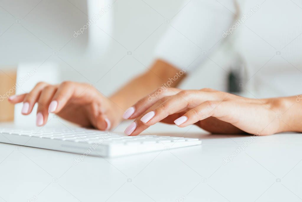 cropped view of broker typing on computer keyboard in office 