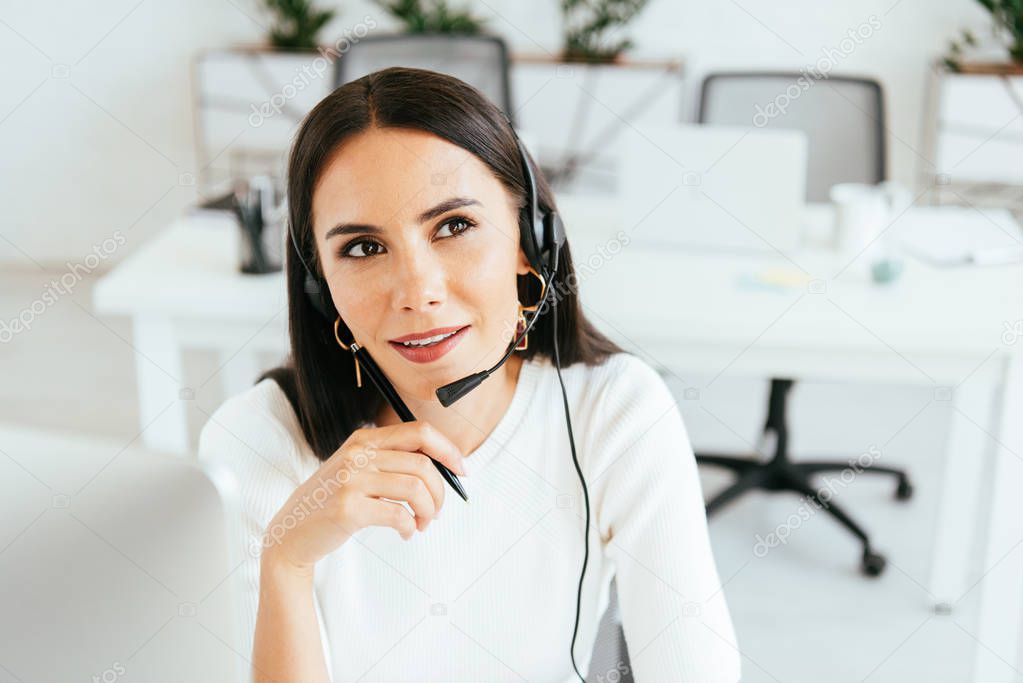 selective focus of pensive broker in headset holding pen in office 