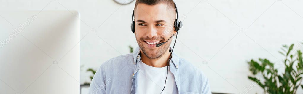 panoramic shot of happy operator in brokers agency looking at computer monitor in office 