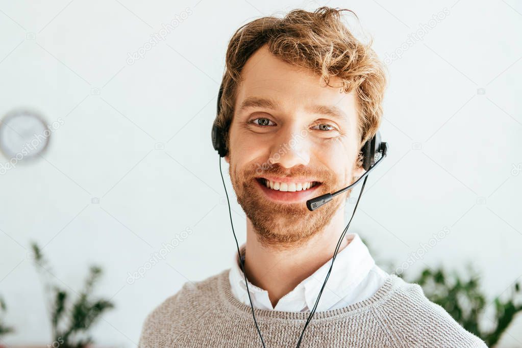 cheerful bearded operator in brokers agency looking at camera