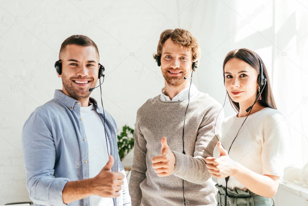 happy brokers in headsets showing thumbs up 