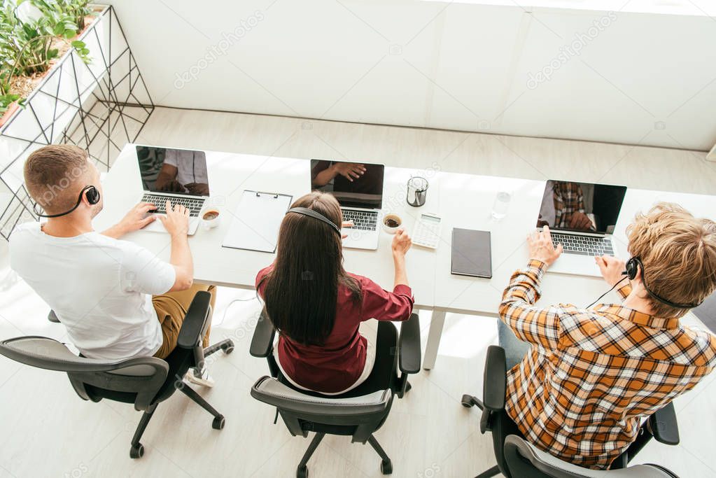 overhead view of brokers in headsets working in call center 