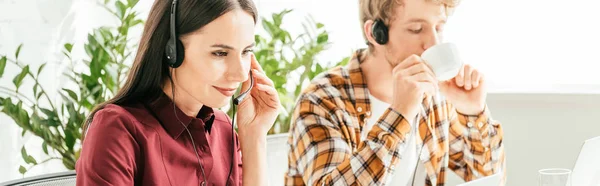 Tiro Panorámico Corredor Tocando Auriculares Cerca Hombre Beber Café Oficina —  Fotos de Stock