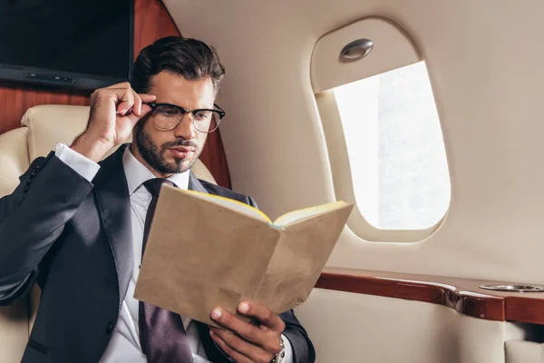 Όμορφος Επιχειρηματίας Βιβλίο Ανάγνωσης Κοστουμιών Ιδιωτικό Αεροπλάνο — Φωτογραφία Αρχείου