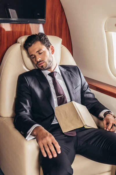 Guapo Hombre Negocios Traje Con Libro Durmiendo Avión Privado —  Fotos de Stock