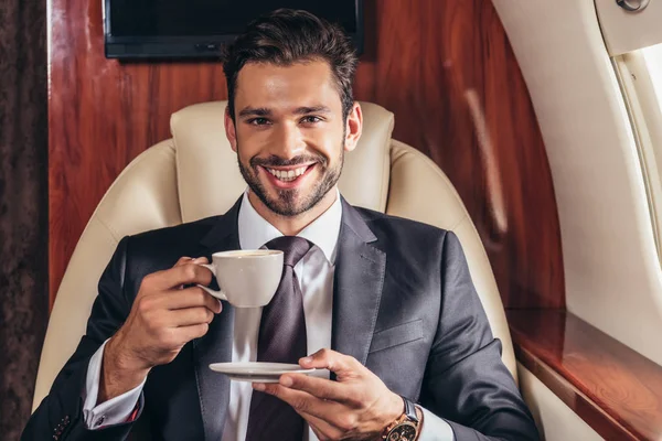 Homem Negócios Bonito Terno Sorrindo Segurando Xícara Café Avião Privado — Fotografia de Stock