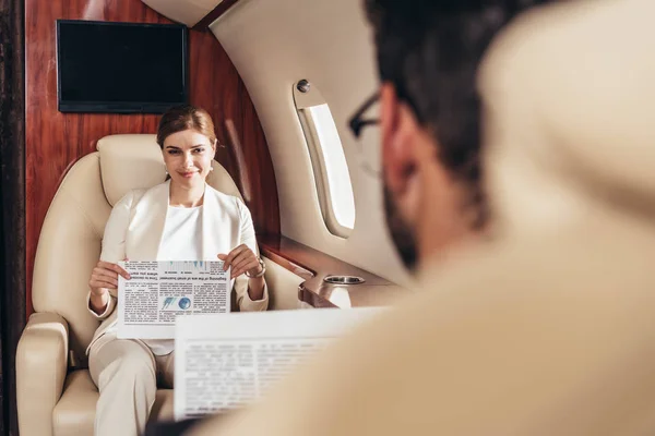 私人飞机上拿着报纸微笑的女商人的选择性焦点 — 图库照片