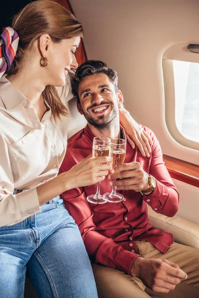 在私人飞机上 笑着的男友和女友与香槟酒杯叮当作响 — 图库照片