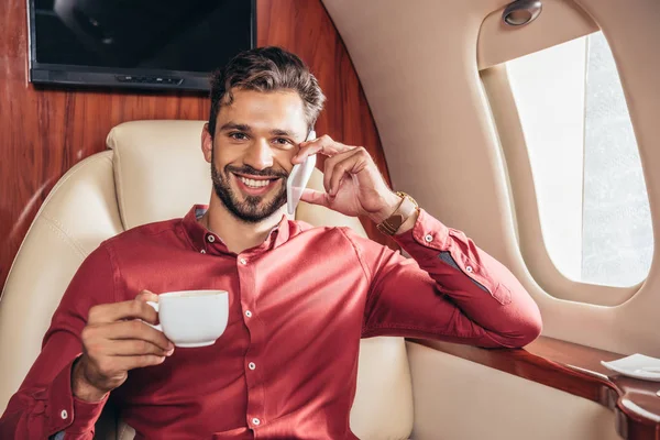 Knappe Man Shirt Praten Smartphone Holding Cup Prive Vliegtuig — Stockfoto