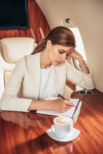 Attractive Businesswoman Suit Writing Notebook Private Plane — Stock Photo, Image