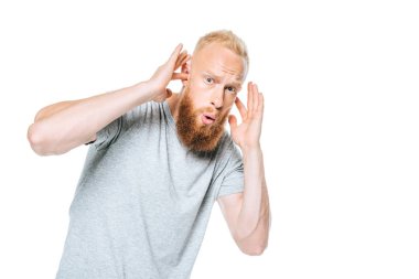 worried bearded man in grey t-shirt closing his ears from loud sound, isolated on white clipart