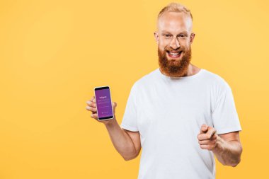 Kyiv, Ukrayna - 27 Ağustos 2019: Instagram uygulamalı akıllı telefon sunan ve seni işaret eden sakallı adam.