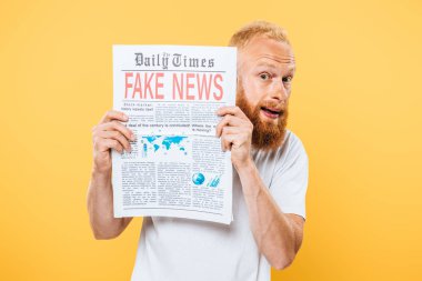 Korkmuş sakallı adam elinde sahte haberlerle gazeteyi tutuyor, sarıda soyutlanmış.