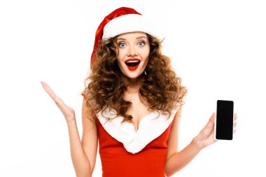 Noel Baba kostümlü heyecanlı kadın akıllı telefon gösteriyor, beyaz tenli.