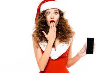 Noel Baba kostümlü sürpriz kız beyaz ekranlı akıllı telefonu gösteriyor.