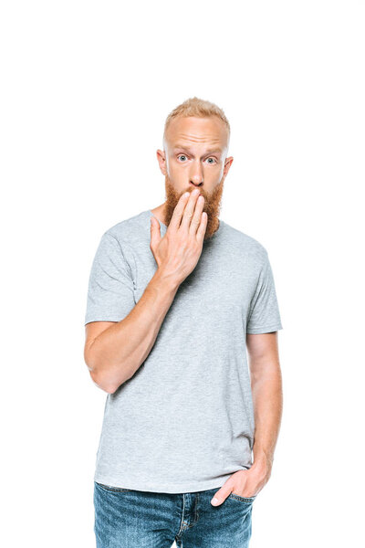 красивый удивленный мужчина в серой футболке смотрит в камеру, изолированный на белом
