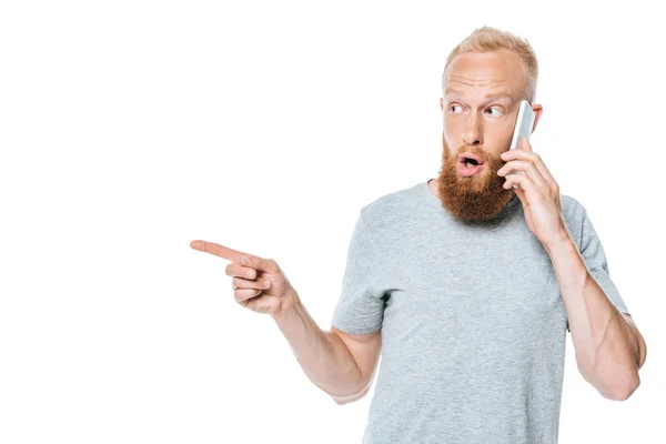 Homem Barbudo Surpreso Falando Smartphone Apontando Isolado Branco — Fotografia de Stock