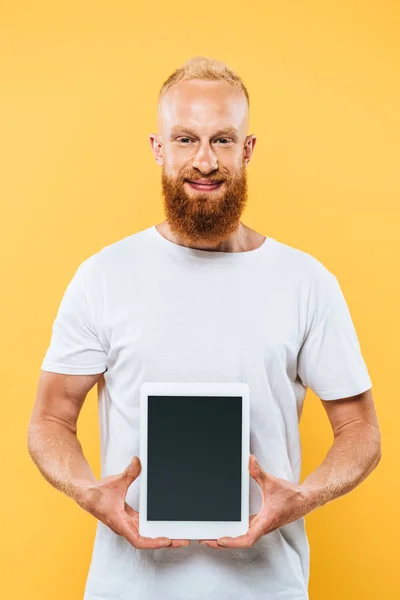 笑顔の髭を生やした男が黒い画面でデジタルタブレットを見せ黄色に隔離され — ストック写真
