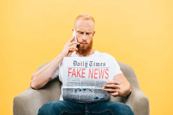 Homem Sério Lendo Jornal Com Notícias Falsas Falando Smartphone Enquanto — Fotografia de Stock