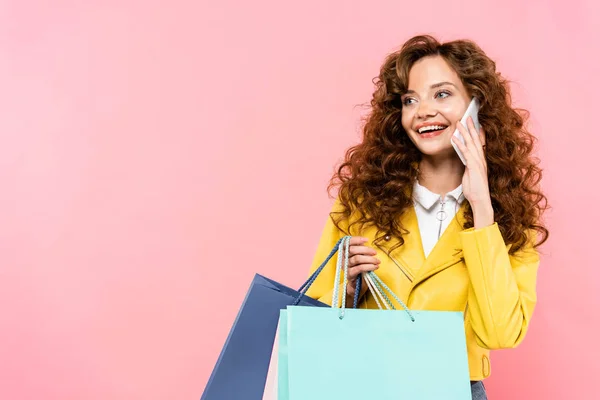 Linda Menina Encaracolado Segurando Sacos Compras Enquanto Fala Smartphone Isolado — Fotografia de Stock