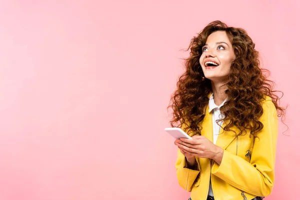 Opgewonden Krullend Meisje Met Behulp Van Smartphone Geïsoleerd Roze — Stockfoto