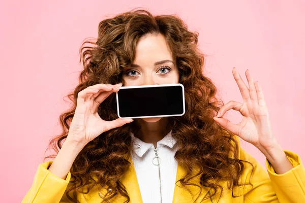 Kręcone Dziewczyna Pokazując Znak Smartfon Pusty Ekran Izolowane Różowy — Zdjęcie stockowe