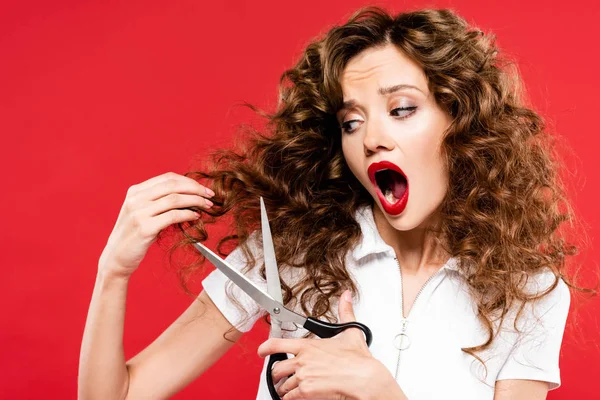 Shocked Curly Girl Cutting Her Hair Scissors Isolated Red — Stock Photo, Image