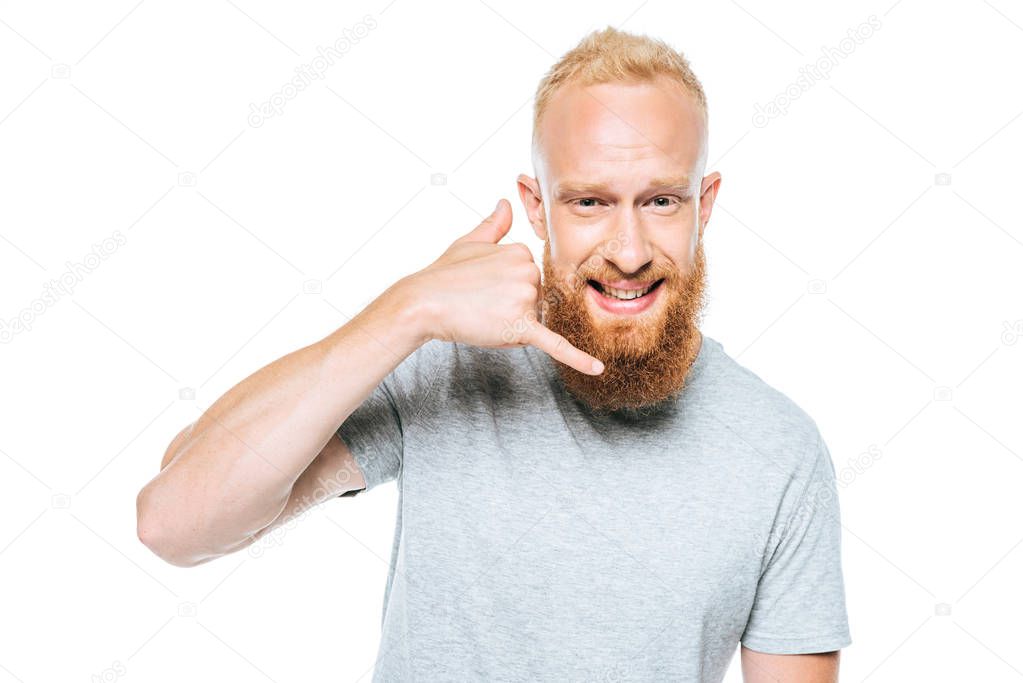 cheerful man in grey t-shirt showing call me gesture, isolated on white