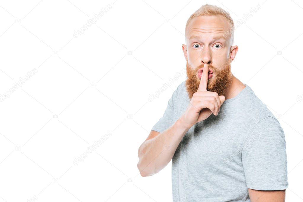 handsome bearded man in grey t-shirt showing silence symbol, isolated on white