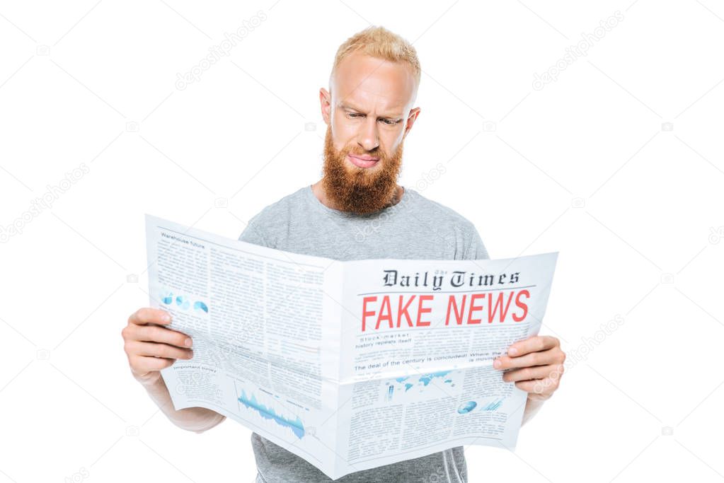 skeptical bearded man reading newspaper with fake news, isolated on white