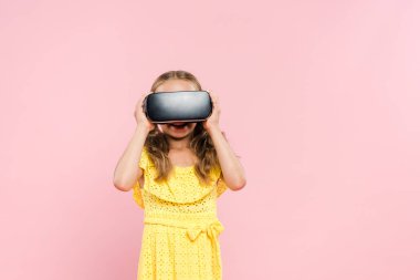 smiling kid with virtual reality headset isolated on pink