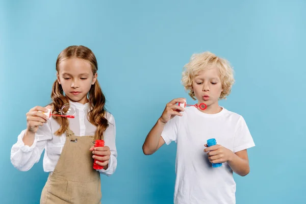 Lindos Niños Sosteniendo Botellas Soplando Burbujas Jabón Sobre Fondo Azul — Foto de Stock