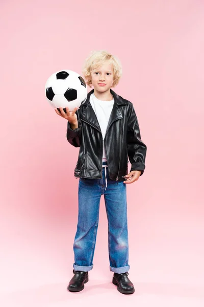 Niño Chaqueta Cuero Sosteniendo Fútbol Mirando Cámara Sobre Fondo Rosa — Foto de Stock