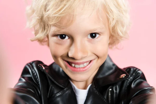 ピンクで隔離されたカメラを見る笑顔の子供の選択的焦点 — ストック写真