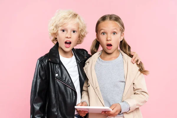 Geschokte Jongen Knuffelen Vriend Met Digitale Tablet Geïsoleerd Roze — Stockfoto