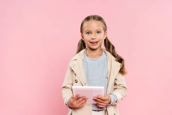 Criança Sorrindo Segurando Tablet Digital Olhando Para Câmera Isolada Rosa — Fotografia de Stock