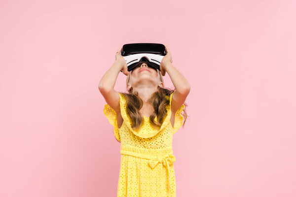 kid with virtual reality headset looking up isolated on pink