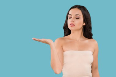 Çekici bir kadın, elleri maviden soyutlanmış olarak işaret ediyor. 