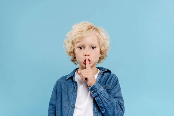 Söt Unge Visar Hemlig Gest Och Tittar Kameran Isolerad Blå — Stockfoto