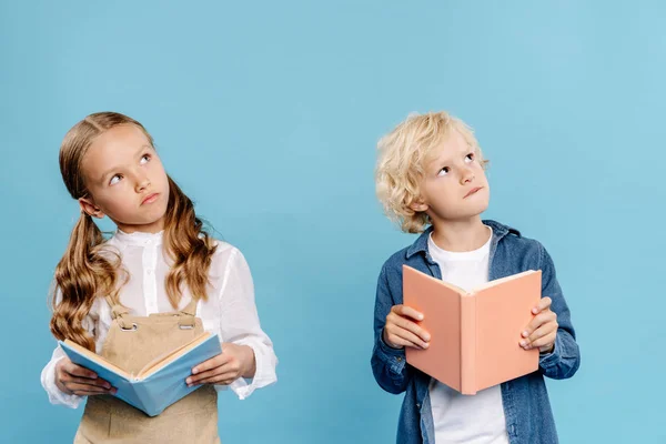 Crianças Bonitos Olhando Para Longe Segurando Livros Isolados Azul — Fotografia de Stock