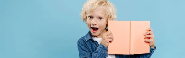 Panoramic Shot Shocked Cute Kid Holding Book Looking Camera Isolated — Stock Photo, Image