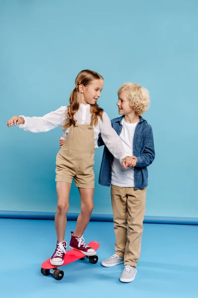 Gülümseyen Sevimli Çocuk Arkadaşının Elini Tutuyor Mavi Arka Planda Bir — Stok fotoğraf