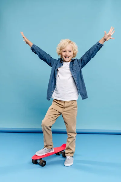 Smiling Kid Outstretched Hands Standing Penny Board Blue Background — Stock Photo, Image