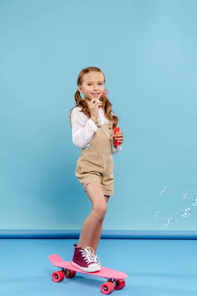 Uśmiechnięte Słodkie Dziecko Stojące Tablicy Groszowej Dmuchające Bańki Mydlane Niebieskim — Zdjęcie stockowe