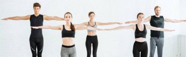 panoramic shot of five young people practicing yoga in mountain open arm pose clipart
