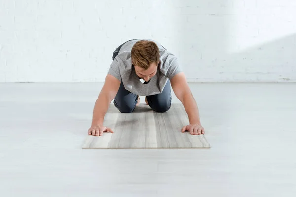 膝の上の板でヨガを練習している若い男のポーズ — ストック写真