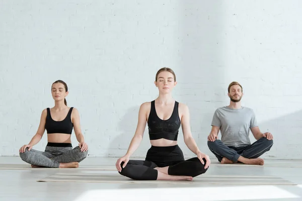 Hombres Mujeres Jóvenes Practicando Yoga Pose Medio Loto — Foto de Stock